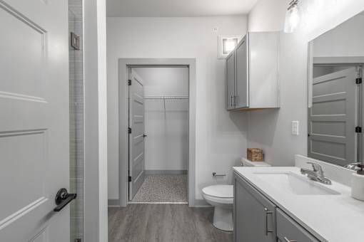 A bathroom with a toilet, sink, and mirror.