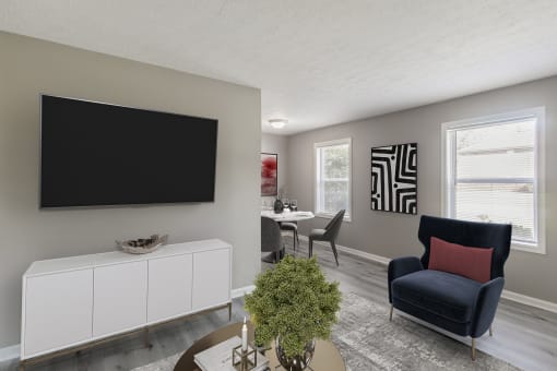 a living room with a tv on the wall and a table and chairs in the background