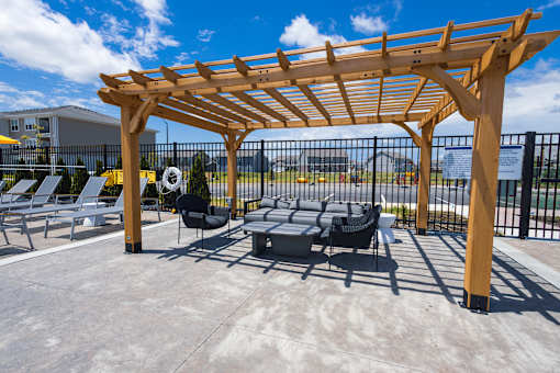 Outdoor patio lounge area with wooden pergola at Allure Apartments, Indiana
