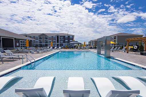 Resort style swimming pool with sun shelf loungers at Allure Apartments, Whiteland, IN 46184