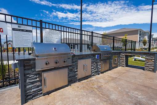 Outdoor kitchen with builtin grills and stone facade at Allure Apartments, Whiteland, IN