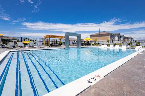Resort style pool with water feature and lounge chairs at Allure Apartments, Whiteland, Indiana