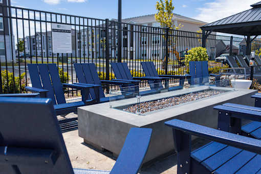 Outdoor fire pit with blue adirondack chairs at Allure Apartments, Indiana, 46184