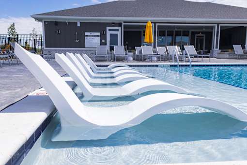 Swimming pool with inwater chaise lounges at Allure Apartments, Whiteland, IN