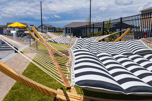 Outdoor hammocks with striped cushions and yellow umbrella at Allure Apartments, Whiteland