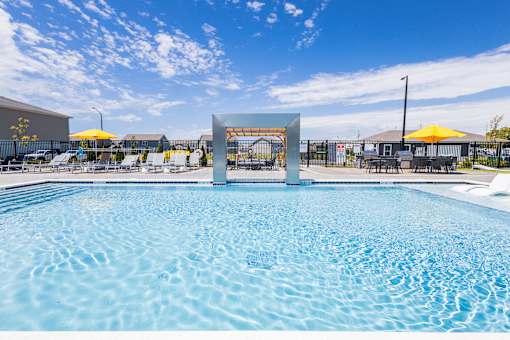 Swimming pool with modern pergola and yellow umbrellas at Allure Apartments, Indiana