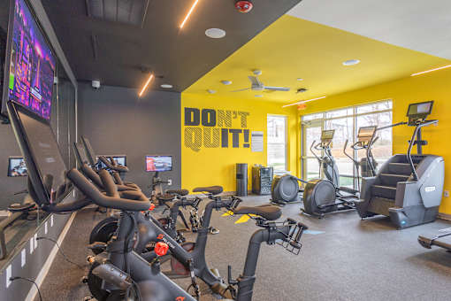 A gym with exercise bikes and a yellow wall with the words "Don't Quit!" on it.