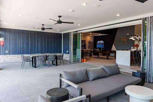 A living room with a grey sofa and a dining table at The Warren Apartments, Jeffersonville, IN