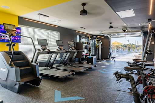 A gym with treadmills, exercise bikes, and other equipment at The Warren Apartments, Jeffersonville, IN