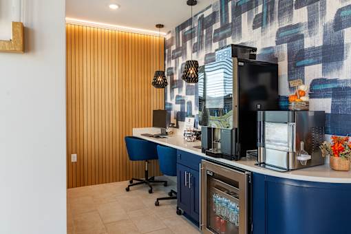 A modern kitchen with a blue chair and a blue counter at The Warren Apartments, Jeffersonville, IN