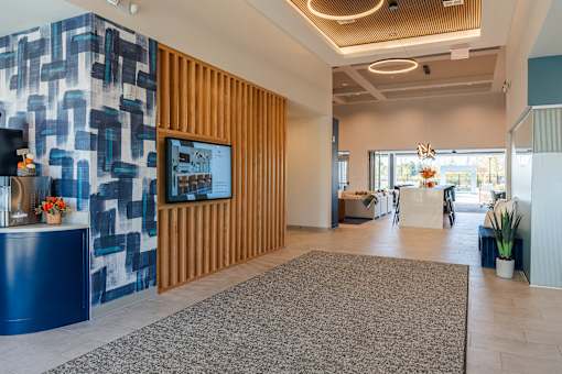 A reception area with a blue and white wall and a wooden panel at The Warren Apartments, Jeffersonville, IN