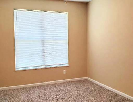 A room with a window covered in blinds.