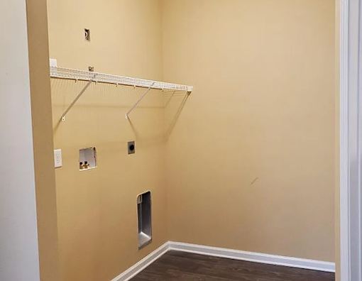 A white shelf is mounted on a wall with a white baseboard.