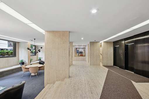A modern office space with a long hallway and a meeting room.