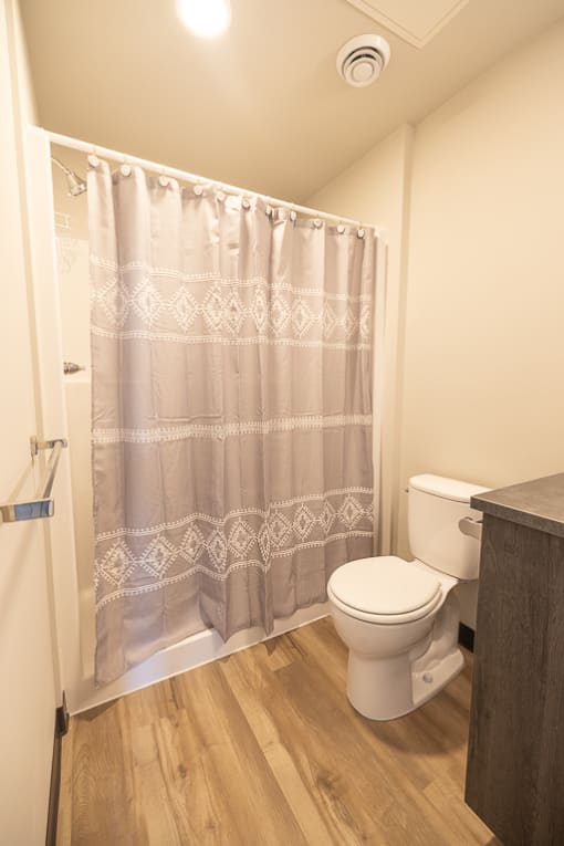 a bathroom with a toilet and a shower curtain