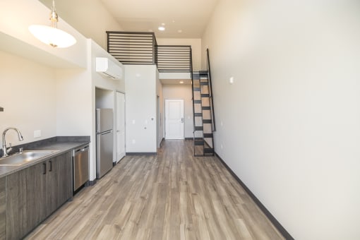 a kitchen with a stainless steel sink and a staircase on the wall