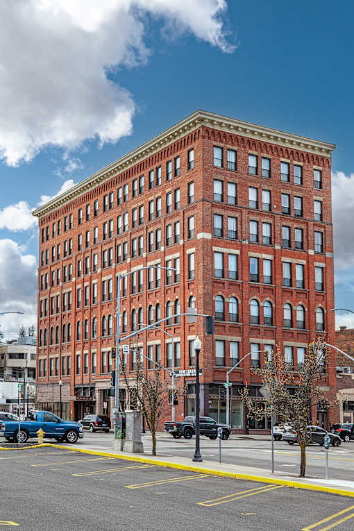 A red brick building with a blue car parked in front at 206 Flats Apartments, Spokane 99201