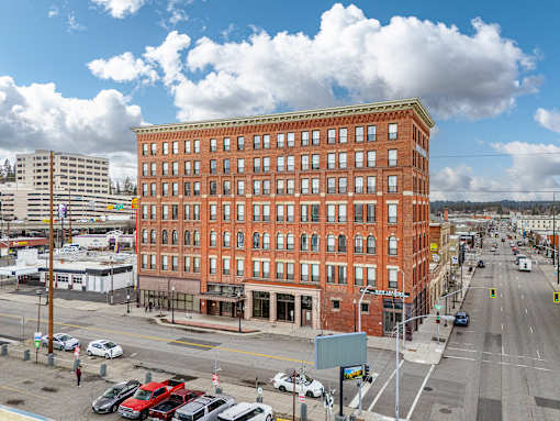 A large red brick building sits on a busy street corner at 206 Flats Apartments, Spokane