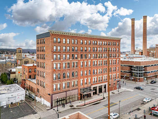 A large red brick building with a parking lot in front at 206 Flats Apartments, Washington, 99201