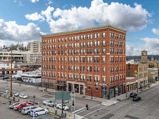A large red brick building sits in the middle of a busy intersection at 206 Flats Apartments, Spokane, Washington