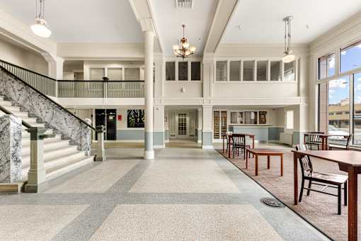 A large open space with a staircase and a long table at 206 Flats Apartments, Washington