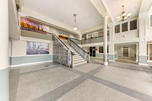 A large, open lobby with a staircase and a painting on the wall at 206 Flats Apartments, Spokane