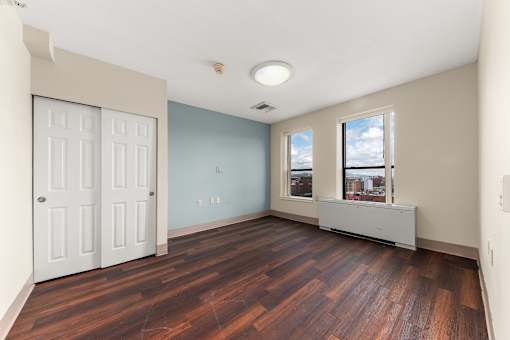 A room with a wooden floor and a window with a view of the city at 206 Flats Apartments, Washington