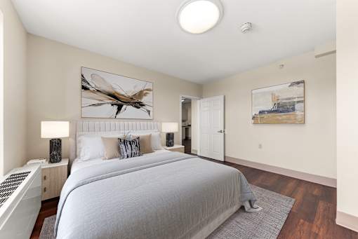 A bedroom with a large bed and a painting of a dragonfly on the wall. at 206 Flats Apartments, Spokane, Washington