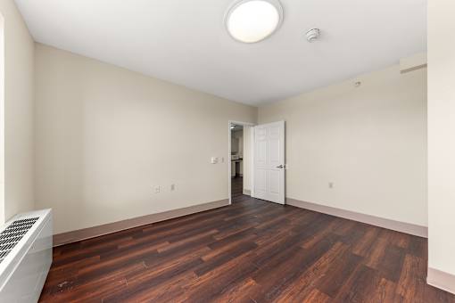A room with a wooden floor and a white ceiling with a light fixture at 206 Flats Apartments, Spokane