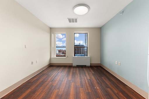 A room with wooden floors and a window showing a cityscape at 206 Flats Apartments, Spokane 99201