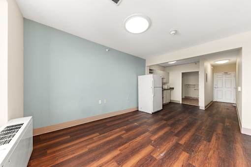 A room with a white fridge and wooden floors at 206 Flats Apartments, Spokane, WA