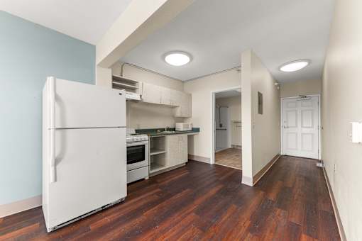 A white refrigerator is in a kitchen with wood floors at 206 Flats Apartments, Spokane, Washington