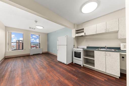 A kitchen with a white refrigerator and wooden floors at 206 Flats Apartments, Spokane, WA