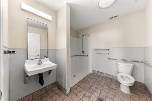 A bathroom with a toilet, sink, and mirror at 206 Flats Apartments, Spokane, WA, 99201