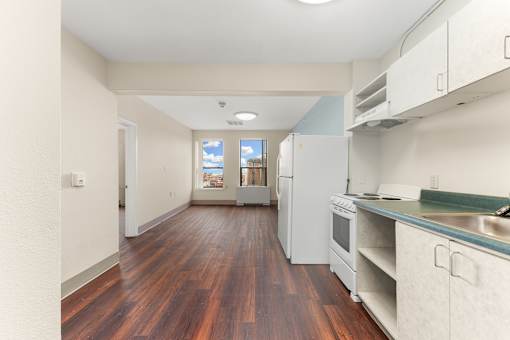 A kitchen with white cabinets and a wooden floor at 206 Flats Apartments, Washington