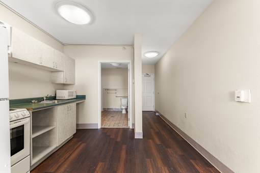 A kitchen with white appliances and wood floors at 206 Flats Apartments, Washington