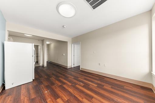 A room with a white fridge and wooden floors at 206 Flats Apartments, Spokane