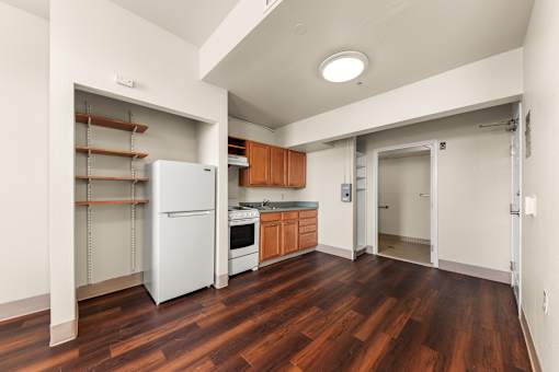 A kitchen with a white refrigerator and wooden floors at 206 Flats Apartments, Spokane, WA