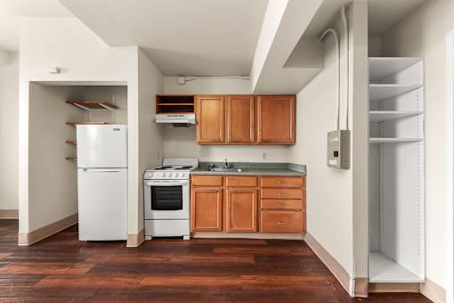 A kitchen with a white fridge, white oven, and wooden cabinets at 206 Flats Apartments, Washington