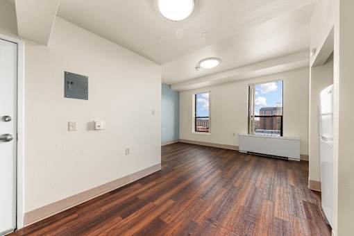 A room with wooden floors and a window showing a cityscape at 206 Flats Apartments, Spokane, Washington