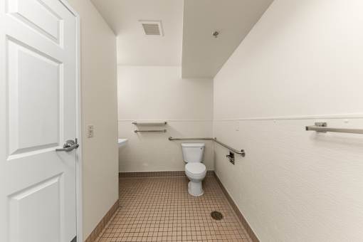 A white door is open to a small bathroom with a toilet and a sink at 206 Flats Apartments, Spokane, WA