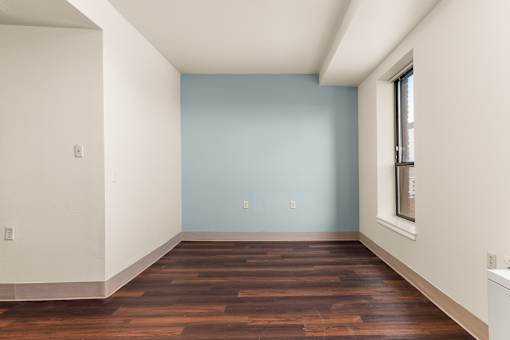 A room with a blue wall and wooden flooring at 206 Flats Apartments, Washington