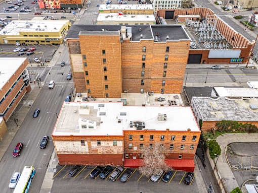 A large red brick building with a parking lot in front at 206 Flats Apartments, Spokane, WA, 99201
