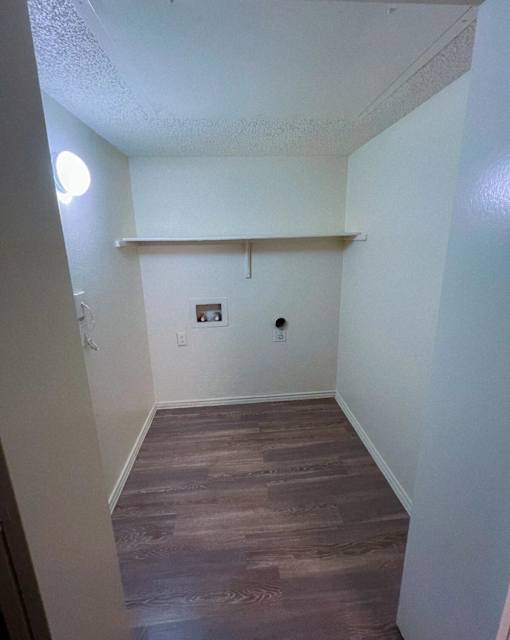a room with a wood floor and white walls and a white shelf