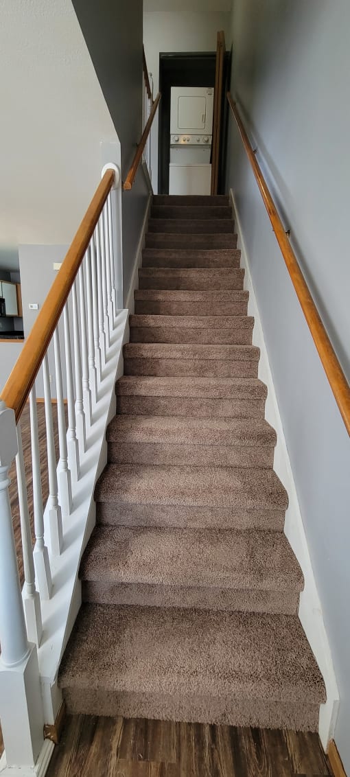 a view from the top of the stairs looking down into the living room