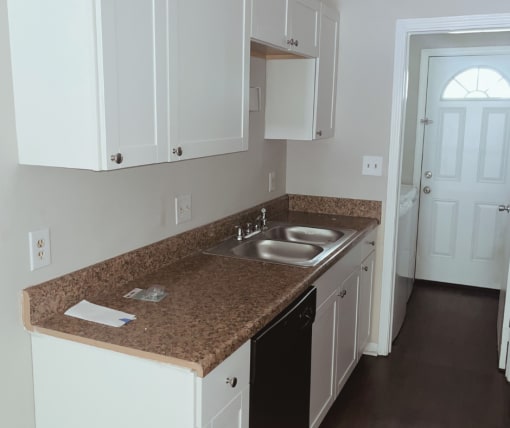 a kitchen with white cabinets and granite countertops