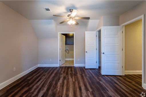 a bedroom with hardwood floors and a ceiling fan