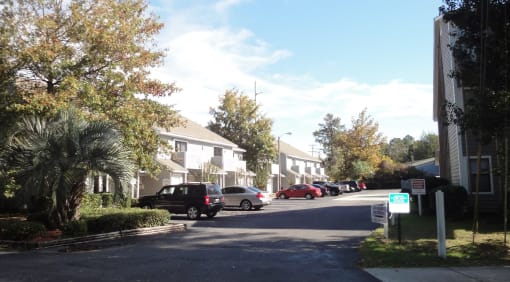a street with houses on either side and cars parked on the side of the road
