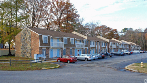 a row of houses with cars parked in front of them