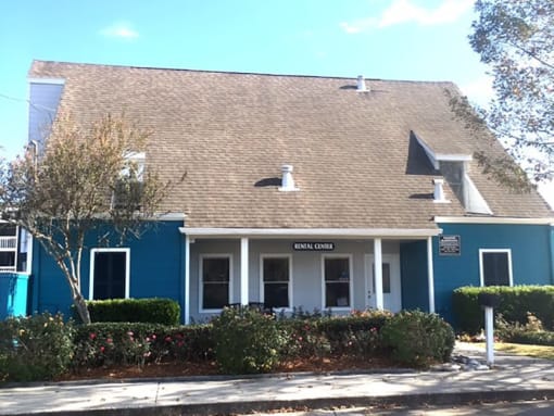 a blue building with bushes in front of it